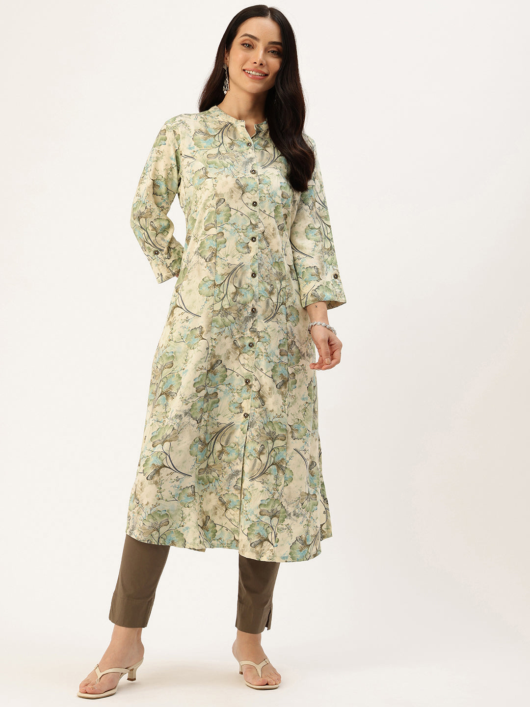 A woman standing and posing in a floral printed band collar kurta in off white and olive green colors, with 3/4 sleeves and a knee-length cut. Off White & Olive Green Floral Printed Band Collar Kurta, Princess Cur Kurta, A-Line Kurta, Floral Print, Mandarin Collar kurta, printed kurta