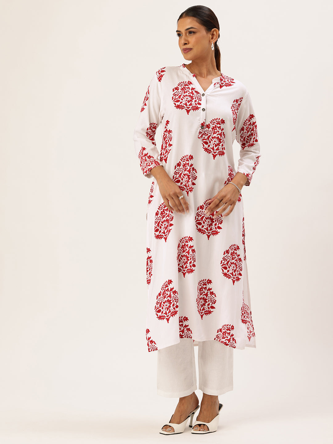 A woman modeling a white floral printed kurta with 3/4 sleeves and a mandarin collar, paired with white pants. A woman modeling a white floral printed kurta with red floral patterns, featuring 3/4 sleeves and a mandarin collar. White Floral Printed Kurta, Princess Cur Kurta, A-Line Kurta, Floral Print, Mandarin Collar kurta, printed kurta
