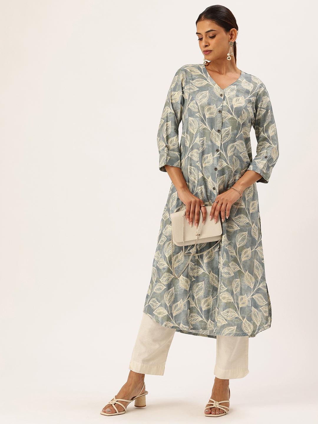 Woman wearing a light blue floral patterned kurta with white pants standing in front of a modern building. Blue Leaf Printed V-Neck Kurta, Princess Cur Kurta, A-Line Kurta, Floral Print, Mandarin Collar kurta, printed kurta